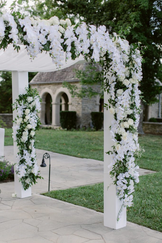 Chuppah adorned in white and green flowers. 