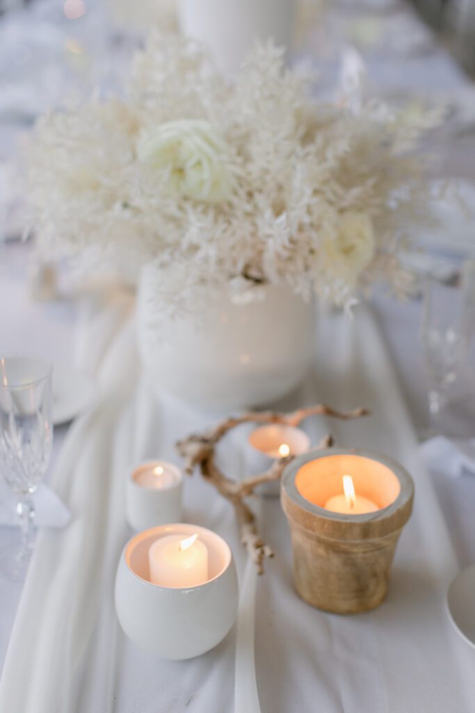 white low centerpiece, white votive candles, wood votive candles