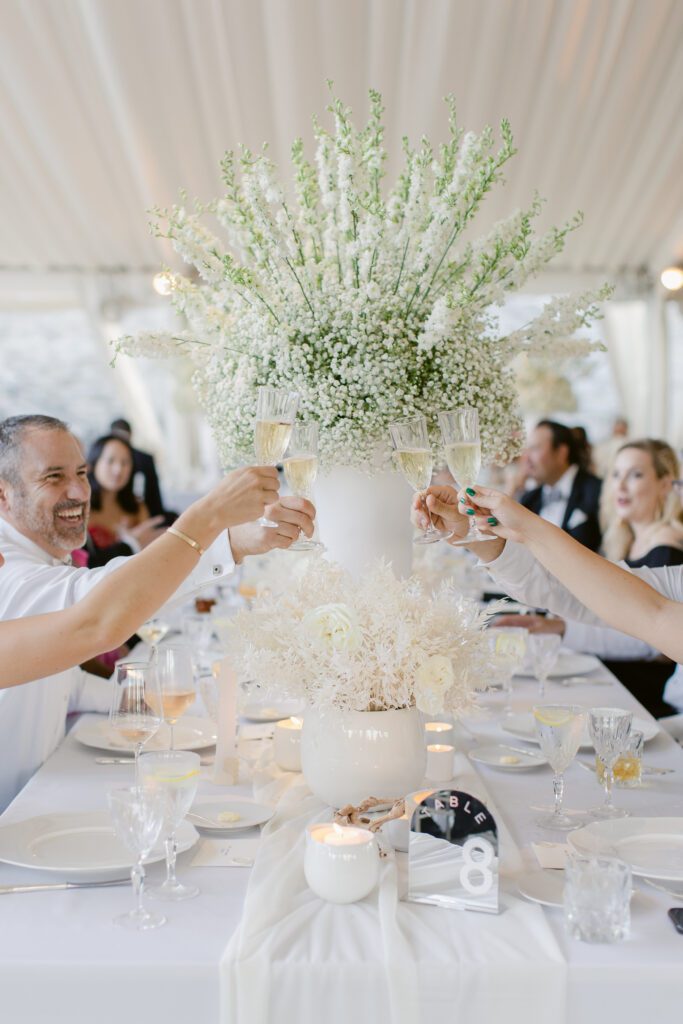 Table 8 cheersing the new couple with a large centerpiece behind them! A beautiful white and green centerpiece. 